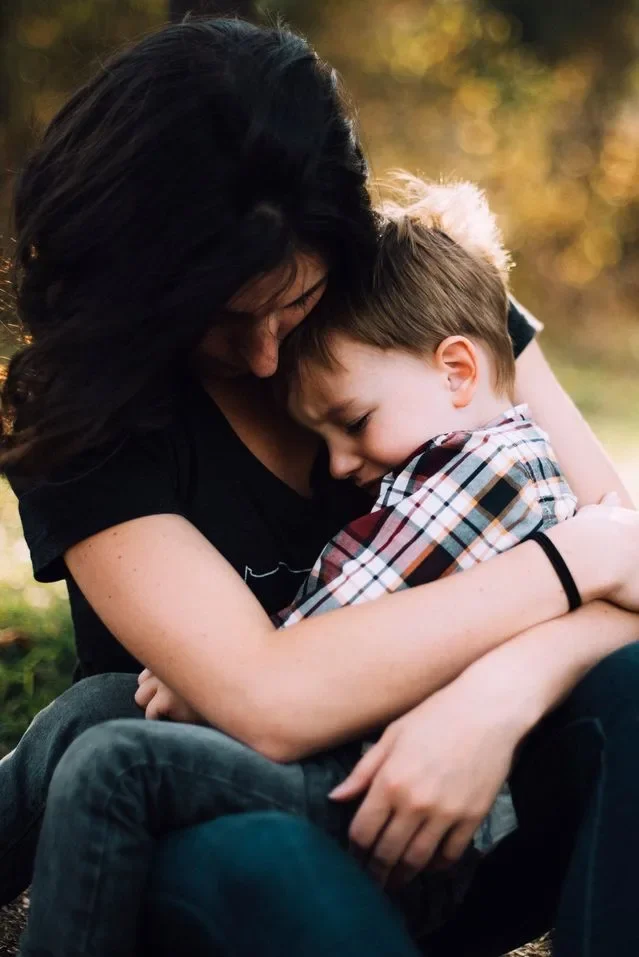 Madre abrazando y consolando a su hijo pequeño durante un momento de frustración